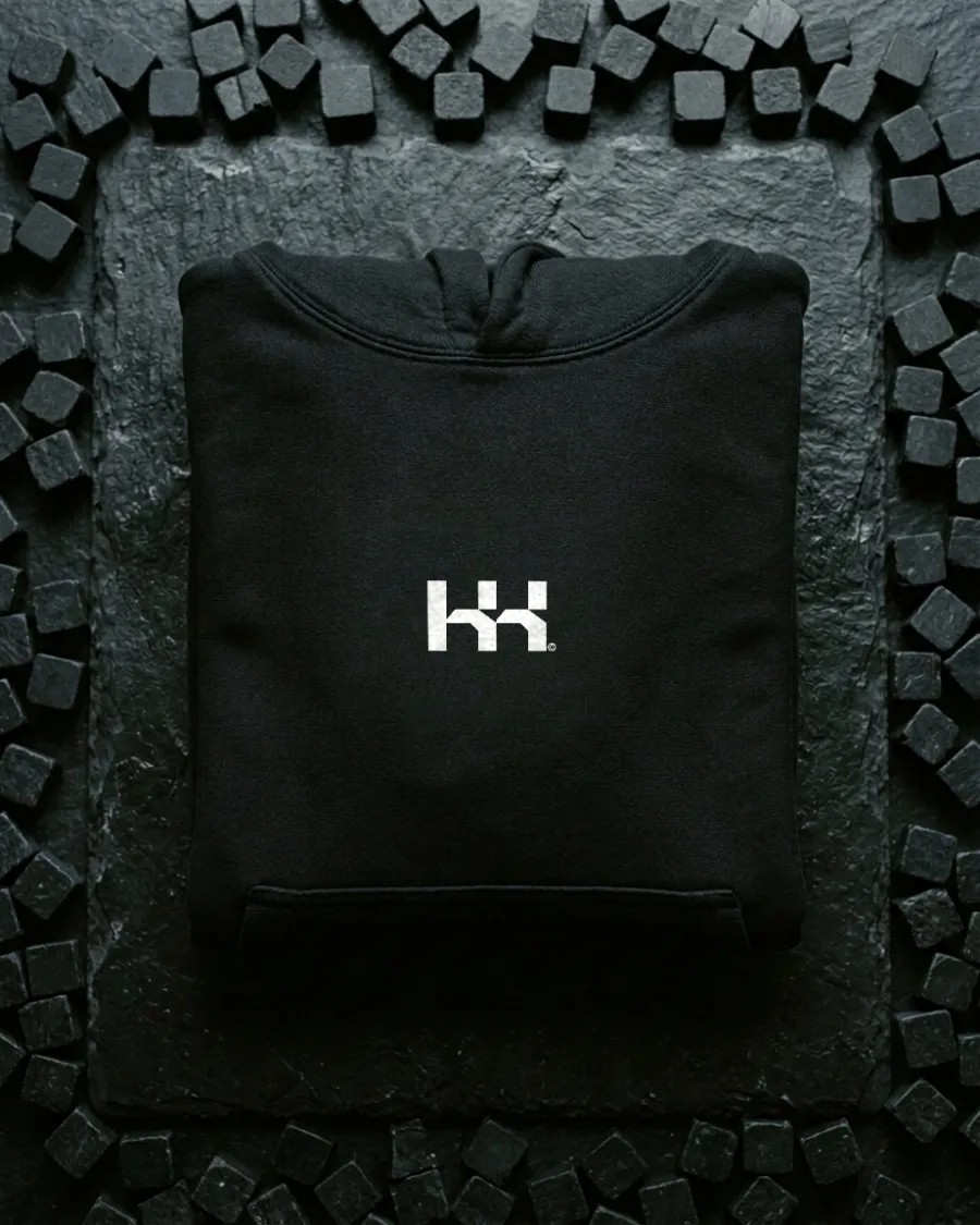 Black hoodie with the white monogram on black stone cubes