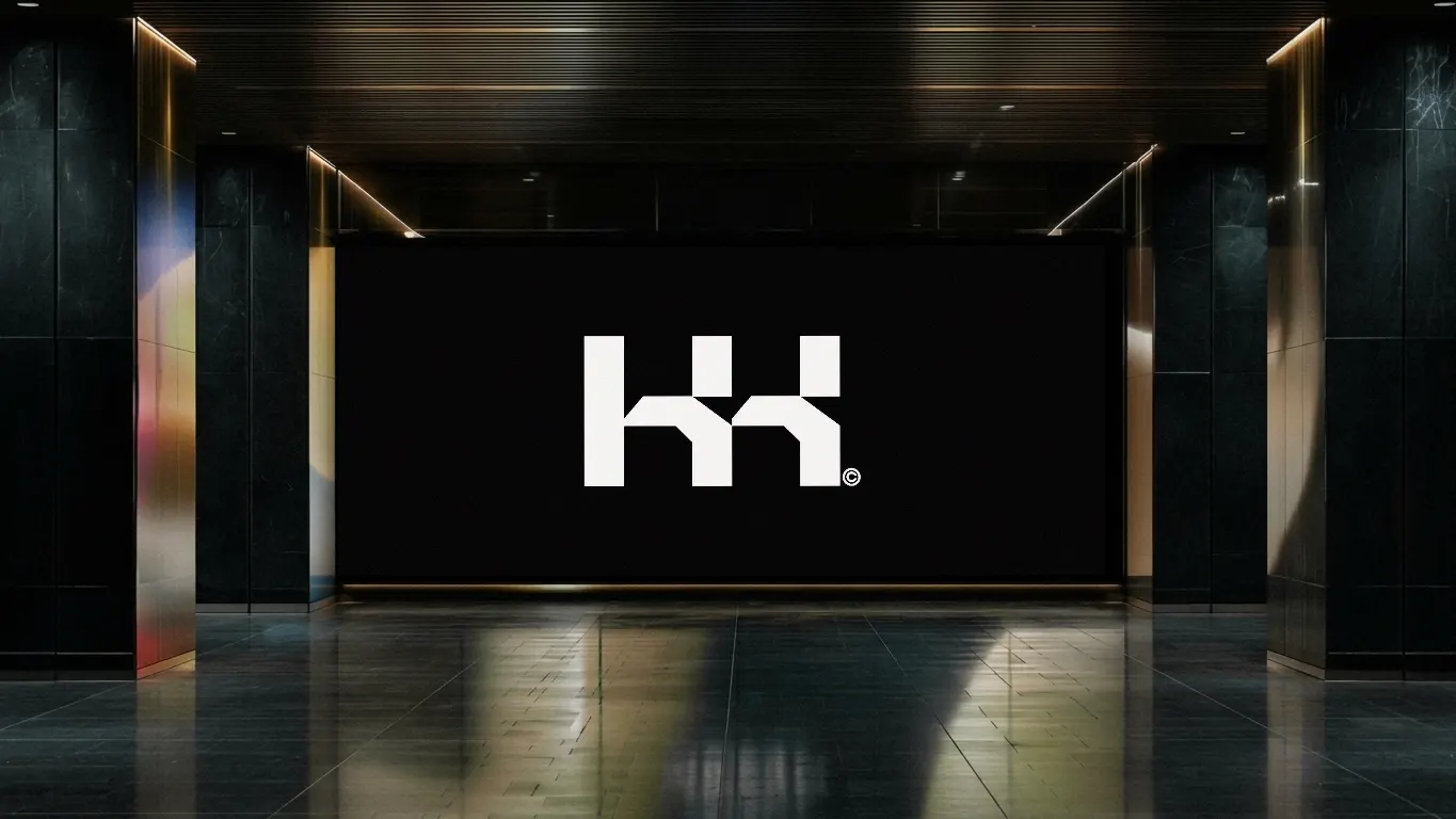 The KK monogram on a large LED wall at the end of a dark corridor
