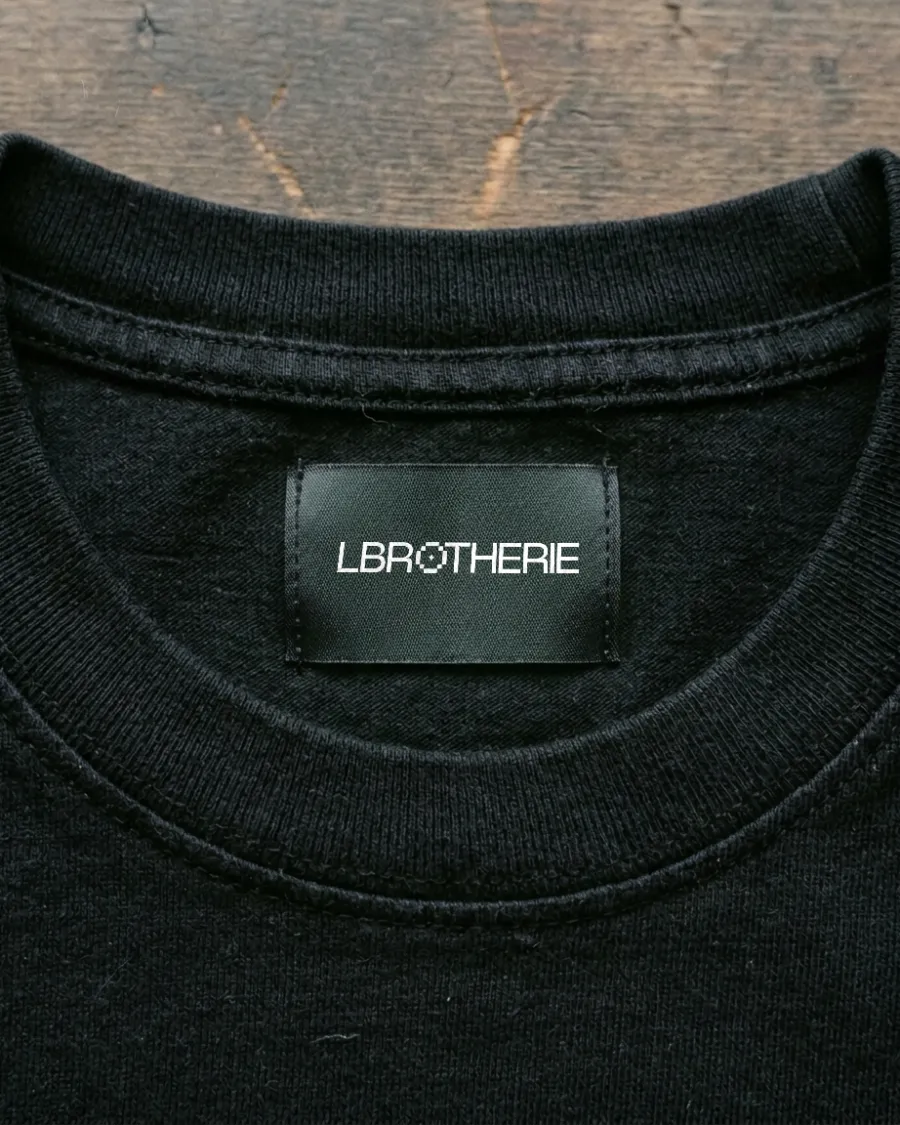 Black woven Lbrotherie label inside a t-shirt collar