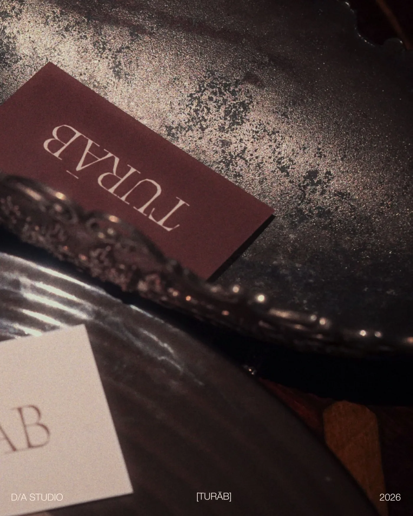 Wine-coloured Turāb business card on an antique tray