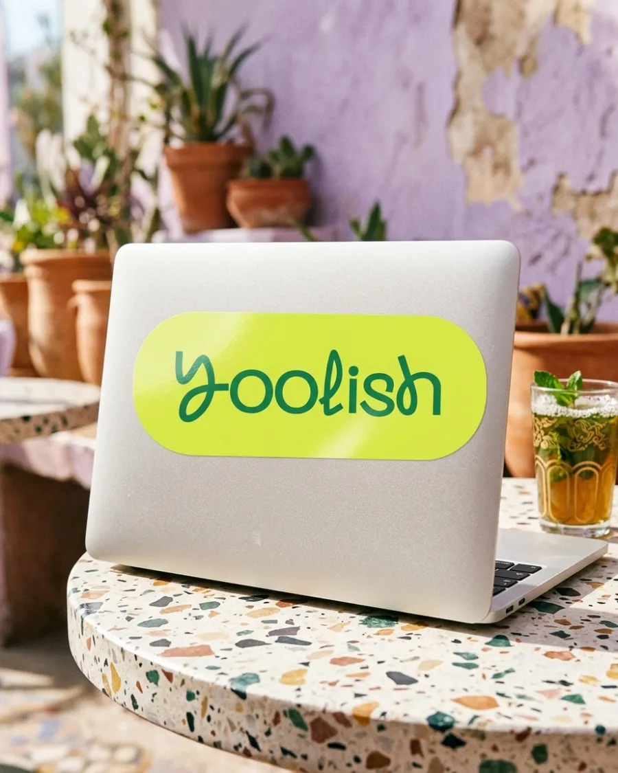 Lime Yoolish sticker on a laptop on a terrazzo café table